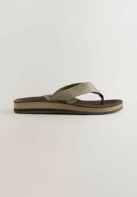 Tongs olive vert avec semelle texturée, fines brides et semelle superposée avec un accent beige. Design flexible et léger.