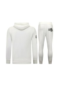 Witte hoodie en bijpassende taps toelopende sweatpants, met ribgebreide manchetten, een trekkoordcapuchon en zwarte logo-accenten op de mouw en achterkant.