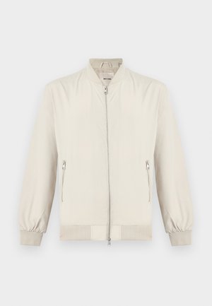 Ανοιχτό μπεζ μπουφάν τύπου bomber με φερμουάρ μπροστά, ριμπ γιακά, μανσέτες, τελείωμα και δύο πλαϊνές τσέπες με φερμουάρ, εμφανιζόμενο σε λευκό φόντο.