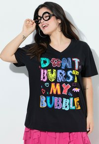 T-shirt nera con scollo a V e testo grafico colorato "NON FAR SCOPPIARE LA MIA BOLLA," con vari caratteri e forme giocose.