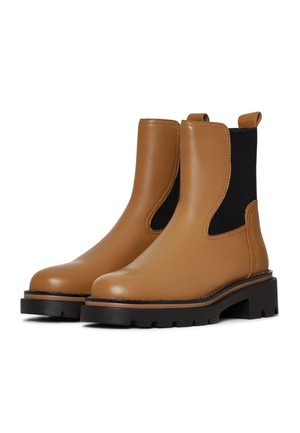 Brown leather ankle boots with elastic side panels, textured black fabric, chunky black rubber soles, and pull tabs at the back.