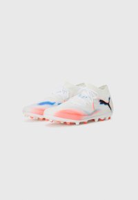 Botas de fútbol blancas de corte bajo con acentos en azul y coral, cordones blancos y logotipo negro de Puma en los lados sobre un fondo blanco.