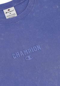 Paarse katoenen T-shirt met een vervaagd uiterlijk, ronde halslijn en geborduurd "CHAMPION" logo met een bijpassend icoon.
