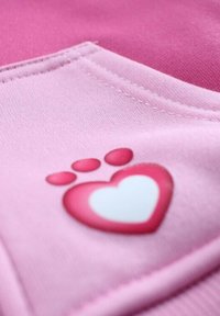 Tissu rose avec un motif de cœur et d'empreinte de patte en nuances de rose et blanc, présentant une texture douce et des coutures visibles.