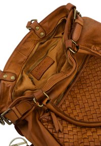 Braune Lederhandtasche mit gewebter Textur und glatter Oberfläche. Das Innere verfügt über ein geprägtes Logo und ein Reißverschlussfach.