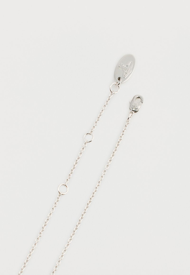 Silver chain necklace featuring oval clasp, links, and circular hardware accents. Smooth finish and delicate design with adjustable length.
