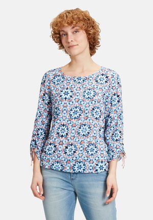 Blaue Bluse mit floralem Muster und Dreiviertelärmeln, mit Kordelzügen an den Manschetten und einem runden Ausschnitt. Aus leichtem Stoff gefertigt.