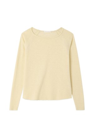 Dolga majica z dolgimi rokavi v svetlo rumeni barvi, izdelana iz mehkega, teksturiranega blaga. Ima okrogel izrez in subtilne šive na ramenih.