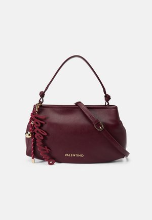 Bordeaux leren handtas met een gouden logo, afneembare schouderriem en een decoratieve "Valentino" hanger. Gladde textuur en gestructureerde vorm.