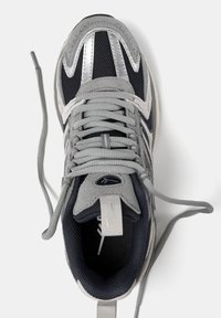 Szare i granatowe buty sportowe wykonane z siateczki i zamszu, z metalicznymi akcentami, sznurowadłami i wyściełanym kołnierzem.