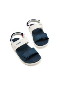 Le sandali Gioseppo presentano cinturini blu navy e bianchi, una soletta testurizzata, chiusure in Velcro regolabili e una suola bianca resistente.