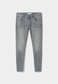 Jeans de mezclilla gris ajustados con bolsillos frontales, cierre de botón y un ligero desvanecimiento en los muslos y las rodillas.