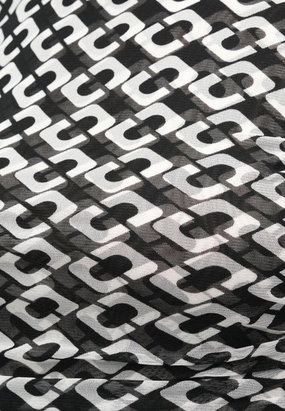 Čierna priesvitná látka so vzorom opakujúcich sa geometrických tvarov bielej farby, ktoré sa preplietajú a vytvárajú textúrovaný a vrstvený dizajn.