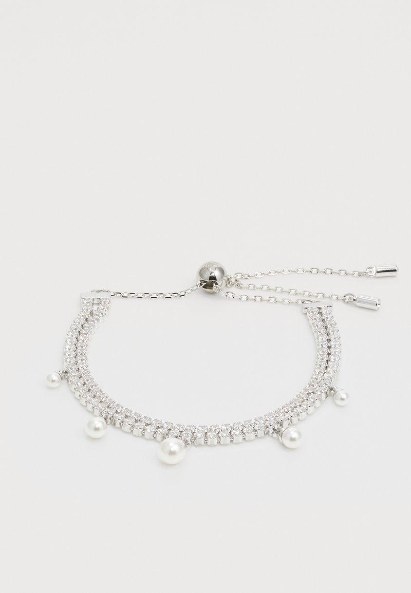 Bracelet en argent avec deux rangées de cristaux transparents, ornée de trois perles blanches. Chaîne réglable avec un fermoir en métal rond.