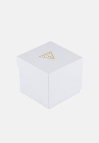 Vit texturerad presentask med en triangulär guld "GUESS"-logotyp på toppen, med en säker flap stängning. Ren, minimalistisk design.