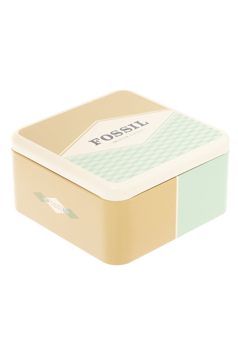 Lata metálica cuadrada con una tapa crema, base dorada y acento verde menta. Presenta la palabra "FOSSIL" en azul marino en la parte superior y los lados.