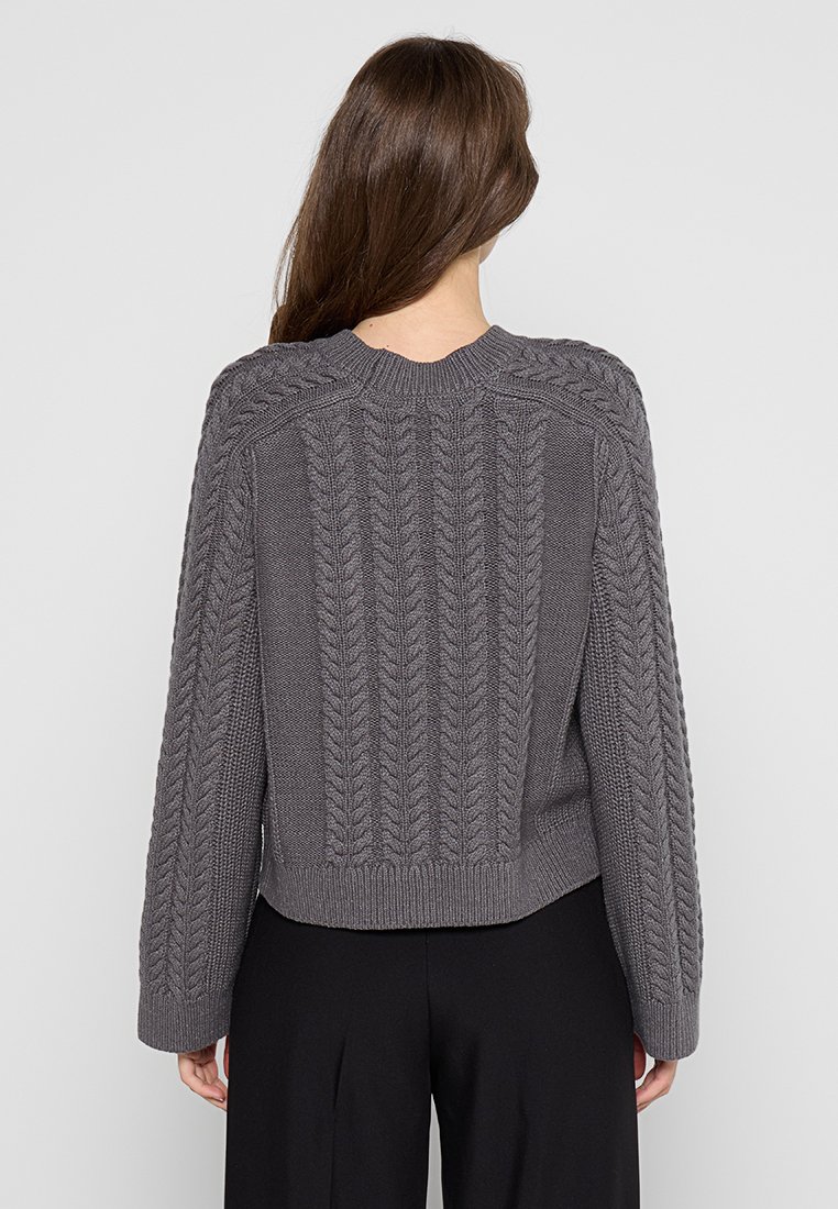 Grauer gestrickter Pullover mit einem strukturierten Zopfmuster, geripptem Saum und langen Ärmeln. Die Rückseite zeigt ein sauberes, nahtloses Design.