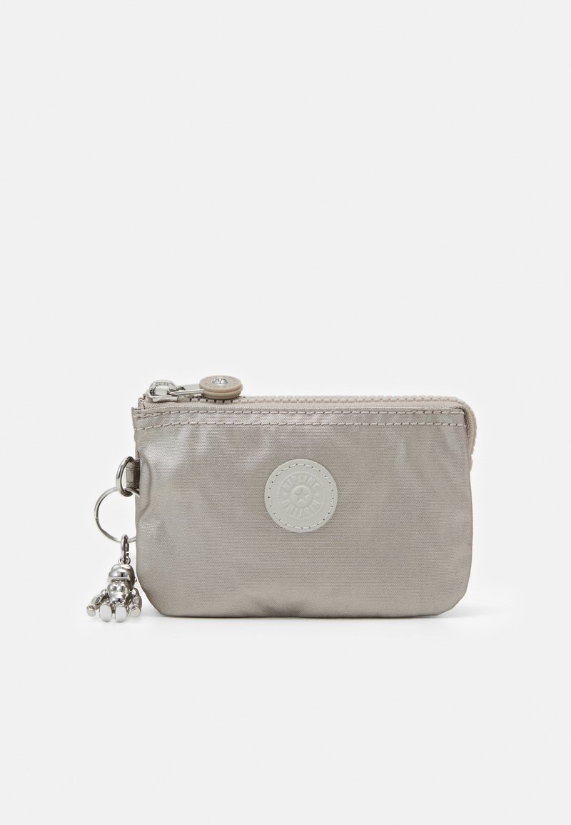 Gray nylon zippered pouch with a circular logo, stitched accents, and a silver charm detail. Compact rectangular shape, smooth texture.