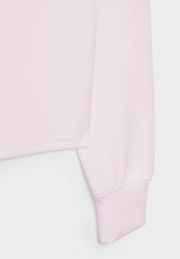 Hellrosa Sweatshirt mit glatter Textur, gerippten Bündchen und lockerem Schnitt. Der Saum ist mit einer schlichten Naht versehen.