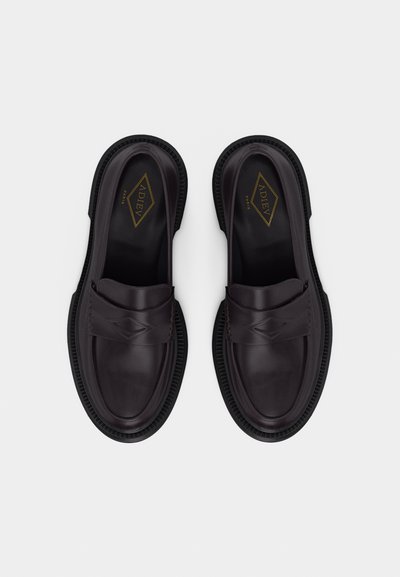 Ζευγάρι από μαύρα δερμάτινα μοκασίνια με στρογγυλεμένες μύτες, διακοσμητικό ραφτό μοτίβο σε σχήμα διαμαντιού στις λουρίδες και υφασμένα λαστιχένια πέλματα, απόψεως πάνω από ψηλά.