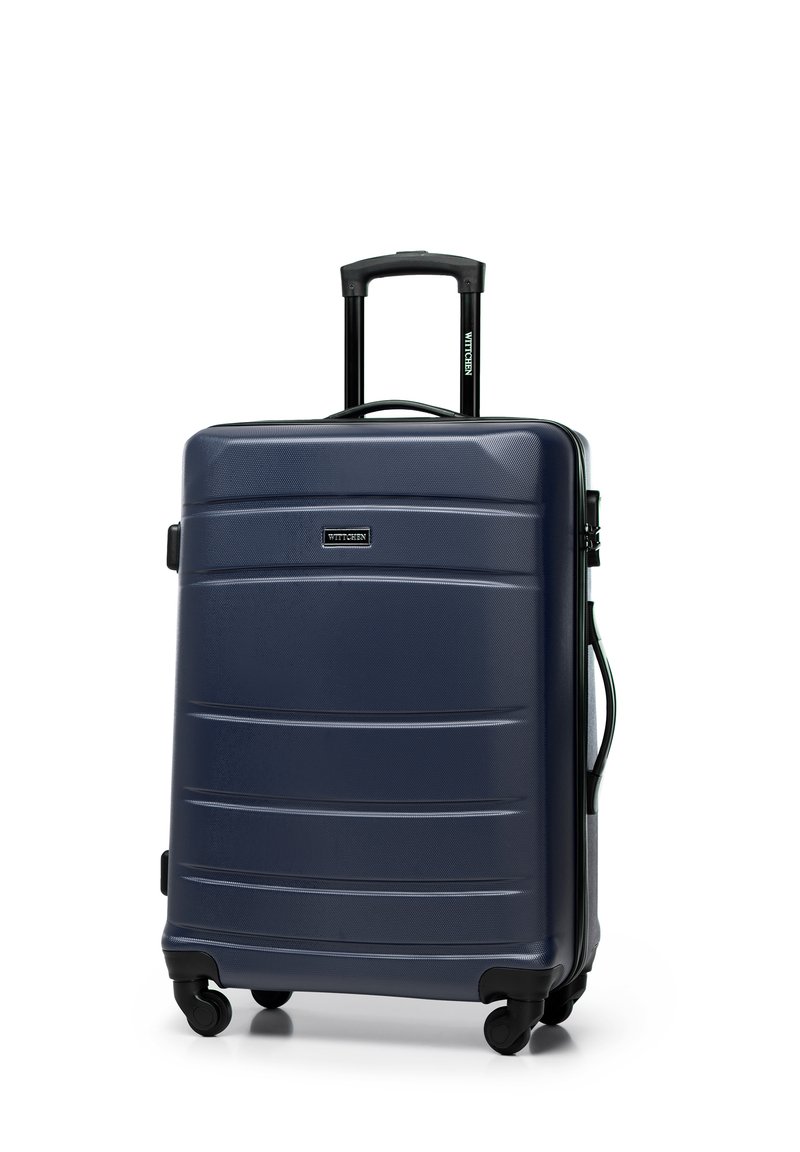 Valigia rigida di colore blu scuro, con texture rigata, due ruote nere, maniglia retrattile e maniglia laterale per il trasporto.