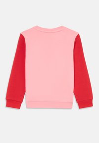 Sudadera rosa con mangas rojas, con cuello redondo y puños acanalados. Tejido suave con una textura lisa, diseñado para comodidad y calidez.