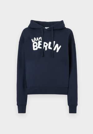 Granatowa bluza z kapturem z kieszenią kangurką. Posiada kaptur ze sznurkiem oraz biały napis "LALA BERLIN" na przodzie. Ściągacze przy rękawach i na dole bluzy.