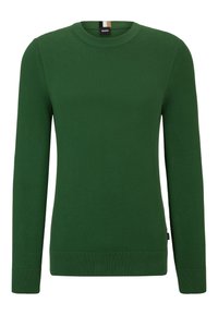 Pull en tricot vert avec un col rond, des manches longues et des poignets et un ourlet côtelés, présentant un motif texturé et une petite étiquette de marque sur le côté.