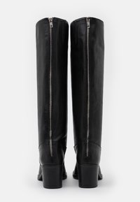 Černé kožené kozačky ke kolenům se dvěma vertikálními zipy na zadní straně, podpatky na blok a hladkou texturou, navržené pro odolnost a styl.