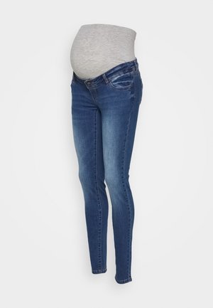 Jeans premaman con un elastico grigio sulla pancia e gambe in denim blu a sigaretta, progettati per il comfort e il supporto durante la gravidanza.