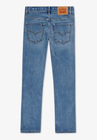Jean en denim bleu clair avec une coupe droite, cinq poches et des coutures contrastées. Doté d'un label en cuir avec le logo à l'arrière de la taille.