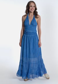 Halternekk blauwe maxi-jurk met een aansluitend lijfje en een gelaagde, vloeiende rok. Gemaakt van een lichtgewicht stof met een zachte textuur.