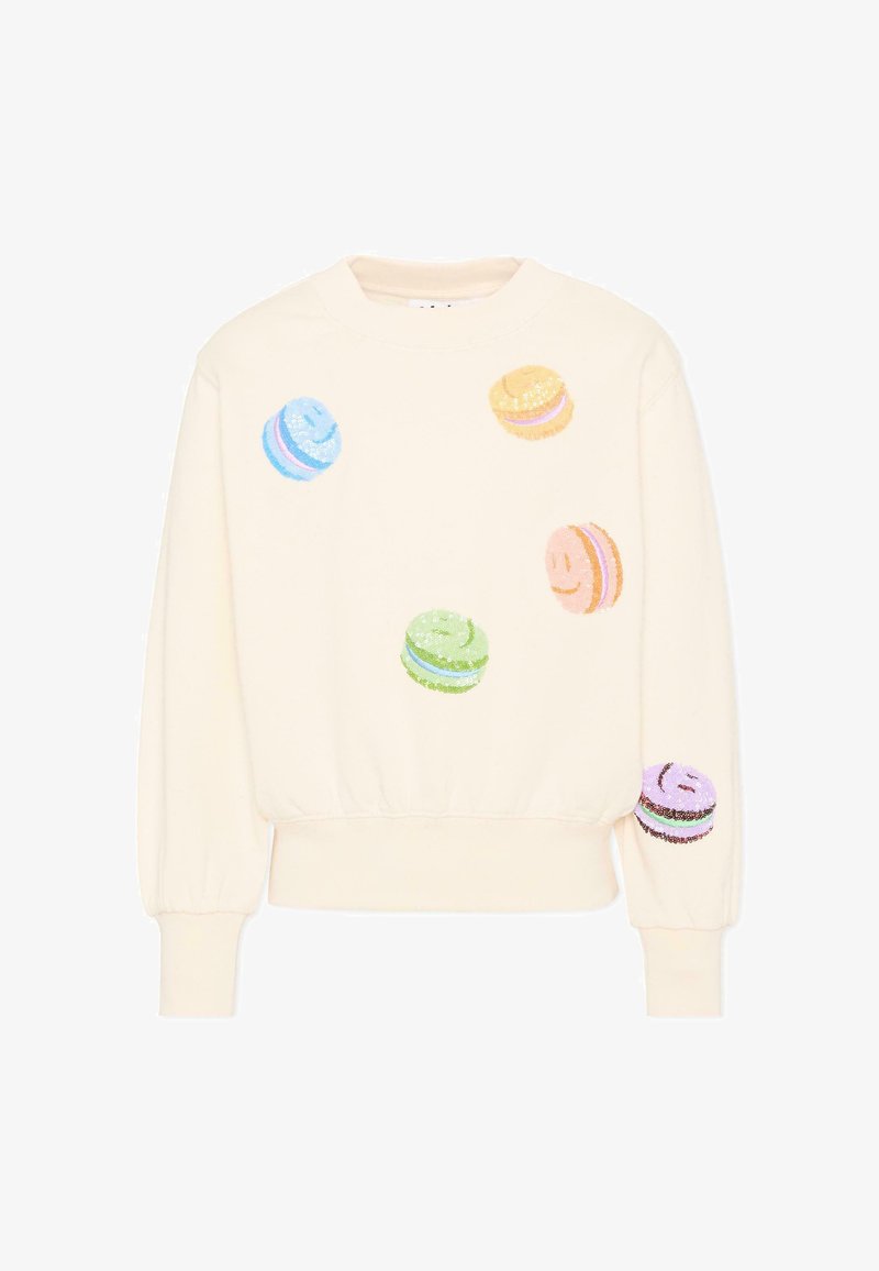 Sweat-shirt couleur crème avec des macarons visage souriant en sequins colorés dispersés sur le devant et la manche droite.