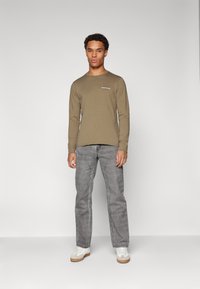 Guess Jeans AMERICAN - Ilgarankovis viršutinės dalies drabužis - olive light green