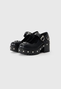 Black platform shoes with rounded toes, featuring a buckle strap, silver studs on the upper and sole, and a textured, chunky heel.