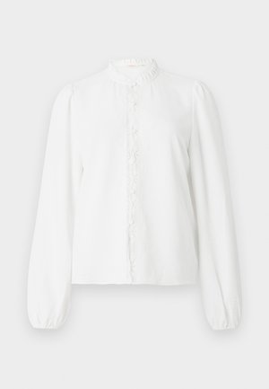 Blusa bianca a maniche lunghe con collo alto arricciato, dettagli in pizzo sulla parte frontale e maniche leggermente gonfie. Tessuto morbido e strutturato.