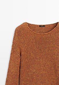 Pull en grosse maille orange rouille avec manches longues et col rond, plié à plat sur fond blanc.