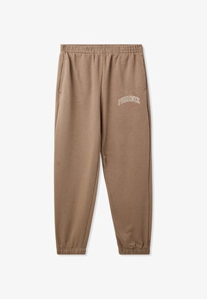 Pantaloni della tuta marroni realizzati in morbido tessuto, con cintura elastica, caviglie a costine e ricamo bianco "PHOENIX" sulla coscia sinistra.