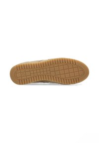 Suela de zapatilla de goma, con una superficie marrón texturizada y un patrón de cuadrícula para mayor tracción; parte superior de ante beige suave parcialmente visible.