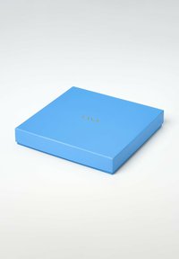 Blå firkantet gaveæske med guld "FAVS." logo centreret på det lukkede låg, placeret på en hvid overflade.