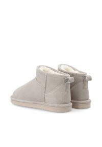 Stivali alla caviglia in suede beige con una morbida e soffice fodera, punta arrotondata e piccolo anello posteriore per facilitare l'indossamento. Suola in gomma leggera.