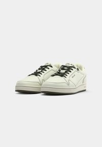 Weiße Low-Top-Sneaker mit schwarzen Schnürsenkeln, dezenten Perforationen und "Replay"-Markenlogo an der Seite und Zunge auf einem schlichten Hintergrund.