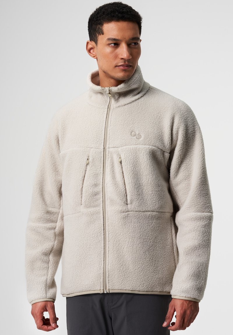 Hellbeige Fleecejacke mit hohem Kragen, Reißverschluss, zwei Brusttaschen und strukturierter Stoff. Mit dezenten Logodetails.