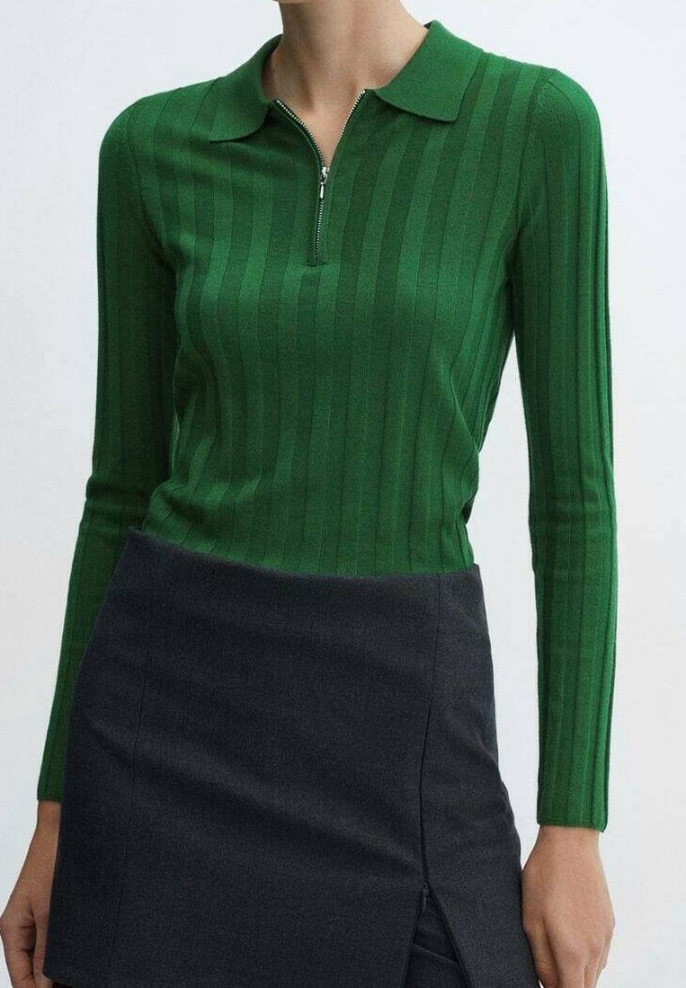 Zelený polo top s dlouhým rukávem a zipovým výstřihem, s vertikálním žebrováním, v kombinaci s tmavě šedou mini sukní s bočním rozparem.