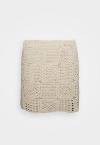 Beżowa spódnica szydełkowa z wzorem kratki, ażurowym splotem, falowanym dołem oraz teksturowaną, lekką tkaniną.