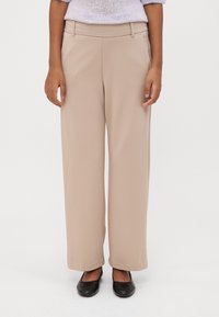 Beige, wide-leg trousers with a smooth texture, featuring a mid-rise waistband and side pockets. Paired with black flat shoes.