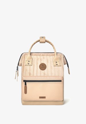 Beige gesteppter Rucksack mit strukturierten Lederakzenten, einer Fronttasche mit Reißverschluss, einem oberen Griff und einem Logo-Patch. Glatte Oberfläche mit Reißverschlüssen und Druckknöpfen.