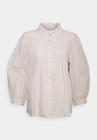 Blusa beige chiaro con frontale plissettato, colletto arricciato e maniche a sbuffo. Presenta leggere fantasie a pois e chiusura frontale con bottoni.
