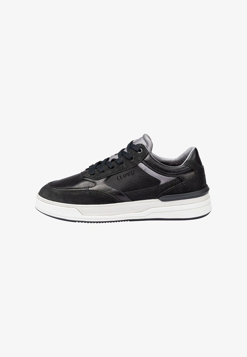 Black leather and suede sneakers with gray accents, cushioned collar, round toe, and white rubber sole featuring textured tread pattern.