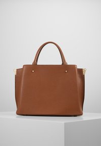 Brązowa skórzana torba typu tote o teksturowanej powierzchni, z dwoma krótkimi uchwytami i złotymi akcentami na rogach.